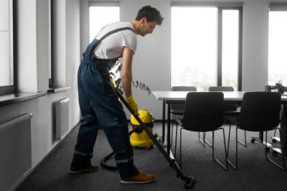 man cleaning indoors with a vacuum cleaner