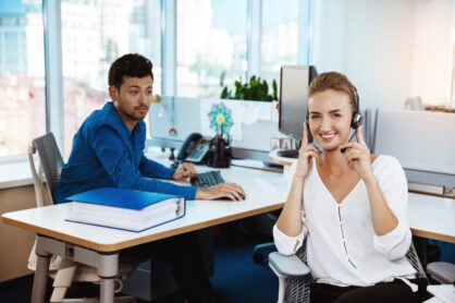 Young female support phone operator speaking, consulting, over office