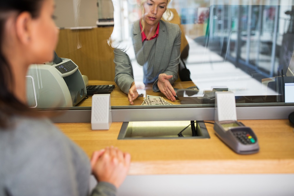 A bank cashier hands over money to a customer