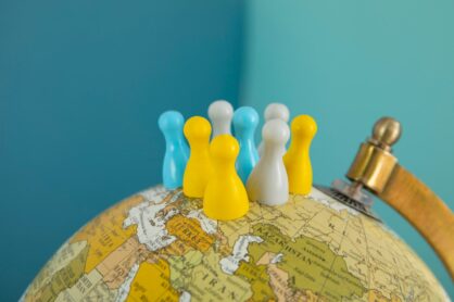 Pawns on world globe with blue background