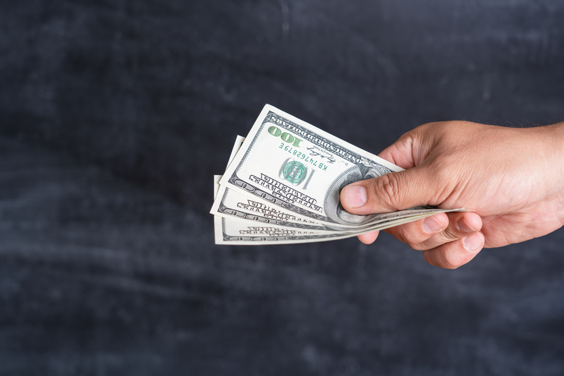 A man offers a bunch of dollars