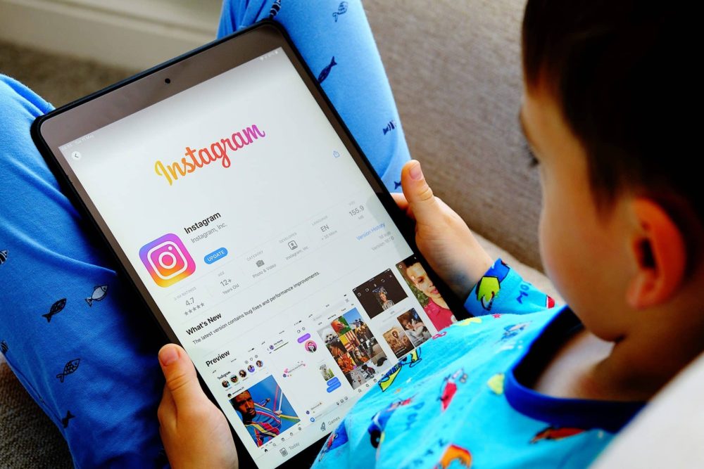 Child holding tab with Instagram logo