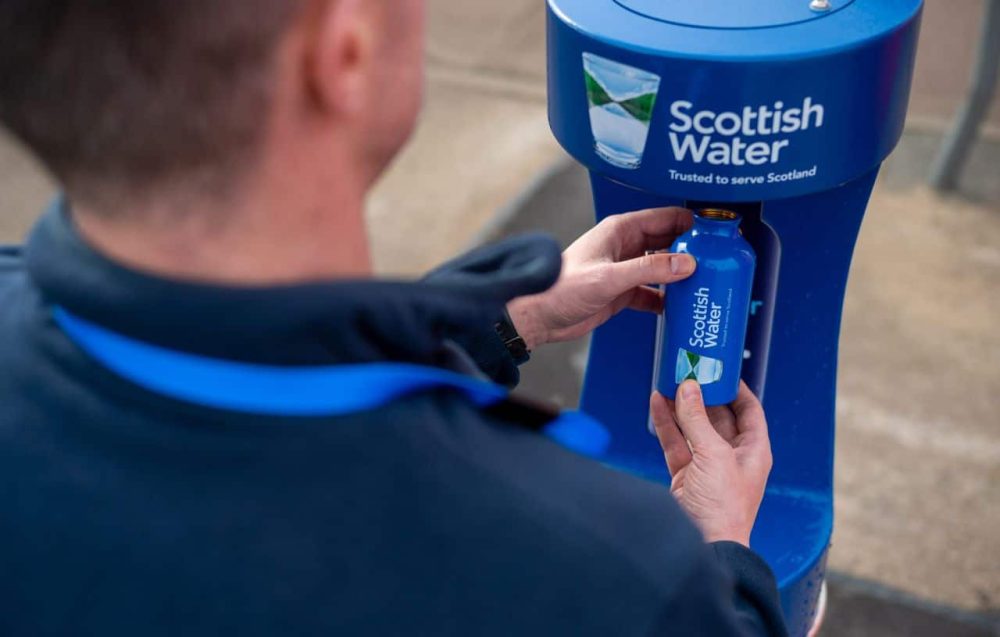 Man taking water from Scottish Water purifier