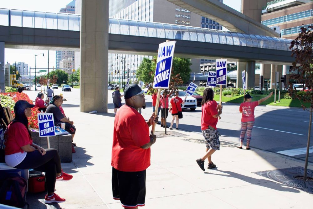 UAW workers striking with signs in front of GM World Headquarters