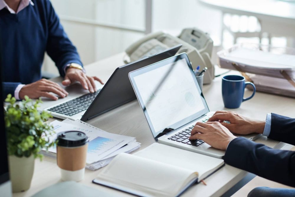 Side view of cropped unrecognizable business people working at common desk