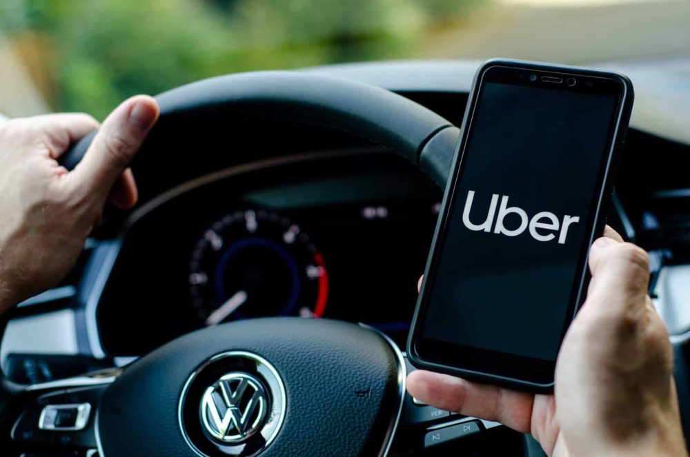 Uber driver holding smartphone in Volkswagen car