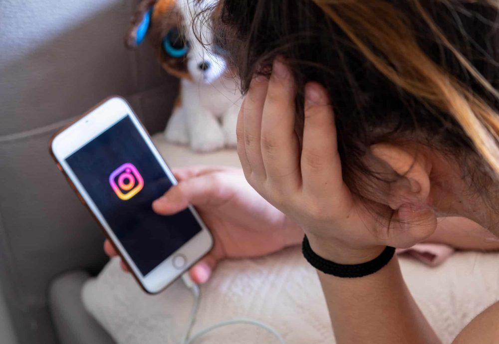 A young girl with the smartphone with Instagram logo displayed on the screen