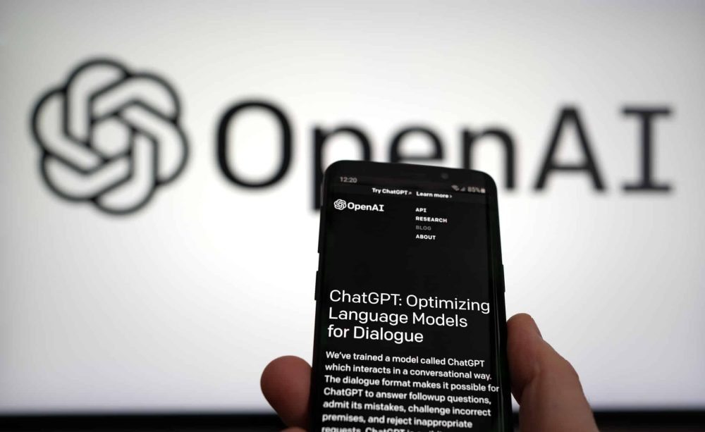 ChatGPT website on a phone screen and OpenAI on the background