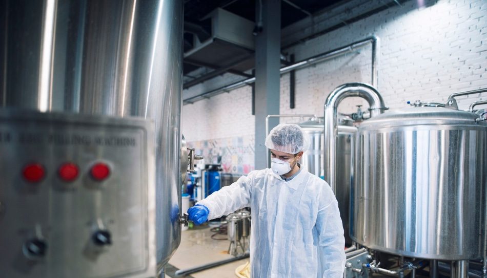 Technologist controlling machine in production plant