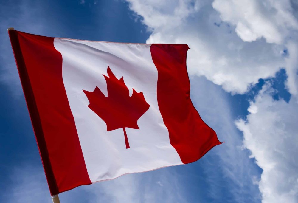 Canada flag on blue sky and clouds