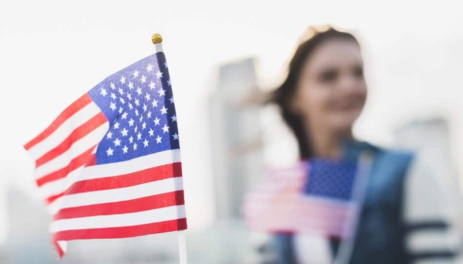 A young girl in the background with an American flag