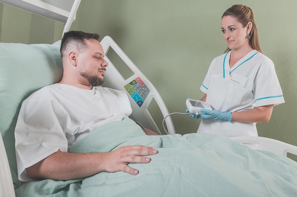 Nurse helping a patient in his bed