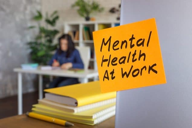 a postinote saing mental health at work in an office