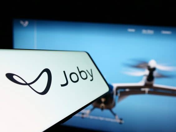 Smartphone with logo of American eVTOL company Joby Aviation on screen in front of business website