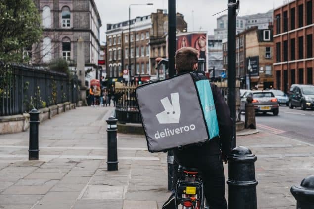 Deliveroo delivery driver on a street in East London