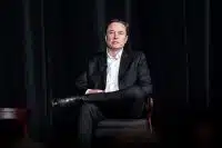 Tesla CEO Elon Musk sitting on a chair