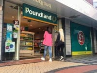 Two women walking inside a Poundland store