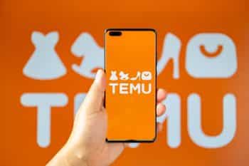 Man holding a mobile with Temu logo at horizontal composition