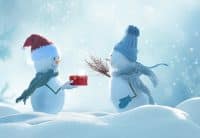 a snowman givng a chrsitmas gift to another snowmen