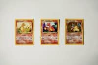 3 Pokemon cards next to eachother which makes up the Charmander eveloution line, Cahrmander, Charemeleon, Chairzard