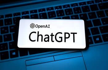 OpenAI's ChatGPT displayed on phone which is placed on a laptop