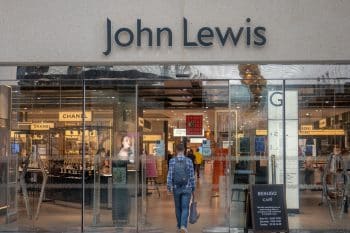 Man walking into John Lewis retail store within the Victoria Quarter complex in Leeds City Centre, UK