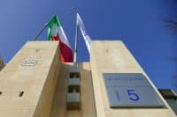 Stellantis automotive corporation logo appear on plate and flags at italian headquarters