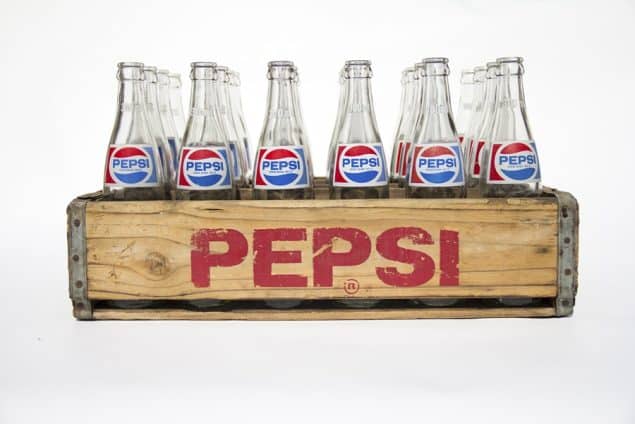 Vintage Pepsi bottles inside a wooden container