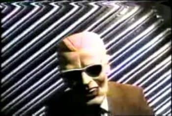An image of a man dressed as TV character Max Headroom, who invaded a tv station in the 1980s
