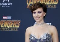 Scarlett Johansson stands in front of an Avengers board